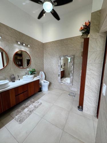a bathroom with a sink and a toilet and a mirror at Villa Montemar Ocean and Mountain Views Elevated 1200 FT with Wifi in Platanillo