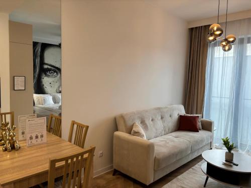 a living room with a couch and a table at ROOSEVELTA RESIDENCE Apartments - przy OFF Piotrkowska in Łódź
