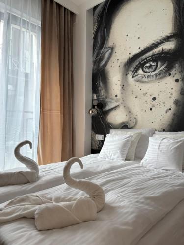 a bedroom with a poster of a woman with an eye at ROOSEVELTA RESIDENCE Apartments - przy OFF Piotrkowska in Łódź