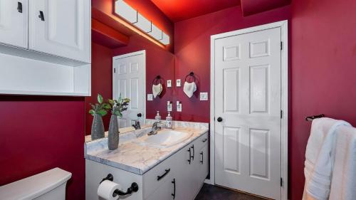 een badkamer met een wastafel en een rode muur bij Knockan Hill Rentals - Ground Floor Suite in Victoria