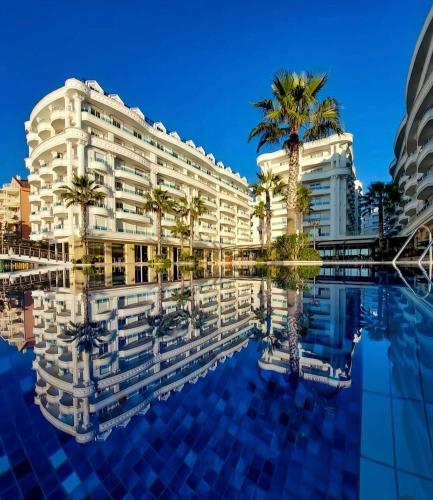 a hotel with palm trees and a swimming pool at Blumoon Holiday in Golem