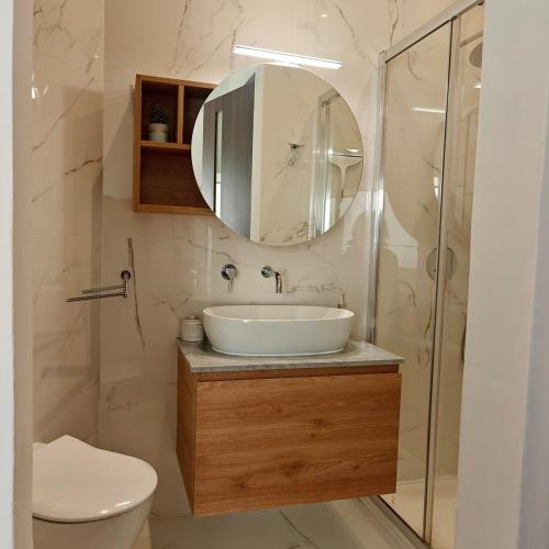 a bathroom with a sink and a toilet and a mirror at 3 bedroom Maisonette in Swieqi in Is-Swieqi