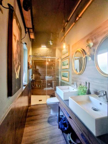 a bathroom with two sinks and a shower and a toilet at The Anchor Townhouse in St Paul's Bay