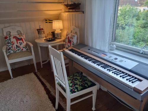 a piano in a room with a table and chairs at Haby House Old in Skene