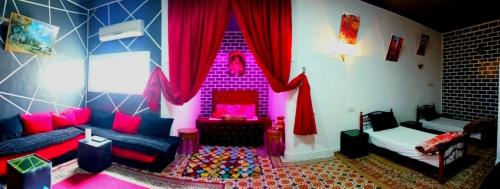 a living room with pink and purple curtains and a couch at Youth housing EL HABIB in Fès