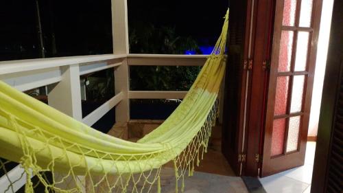 a hammock on a balcony next to a window at La Casa Agus Hospedagem in Búzios