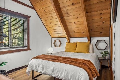 a bedroom with a bed with a wooden ceiling at TreeLicious Jacuzzi Cozy Chalet close to Slopes in Big Bear Lake