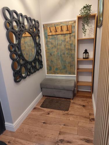 a hallway with a mirror and a bench and a shelf at Somewhere Between Apartments in Piechowice