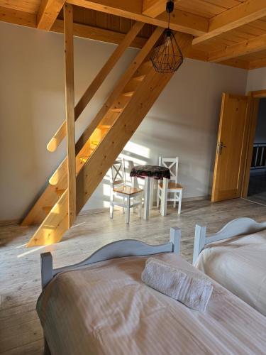 a attic room with two beds and a table at Mecenasówka Noclegi in Zawoja