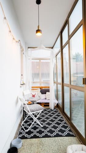 a living room with a white chair and a window at The Loft in Koper