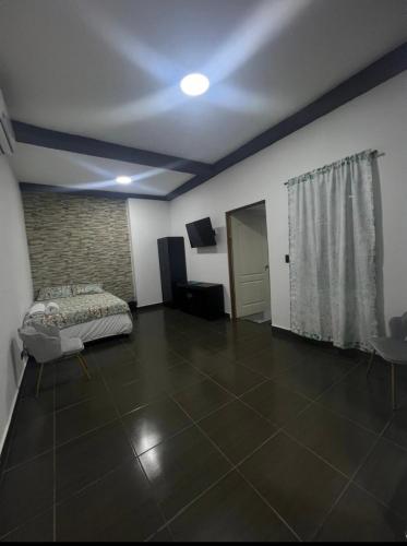 un soggiorno con un letto e un pavimento piastrellato di Mini Apartamento a Nueva San Salvador