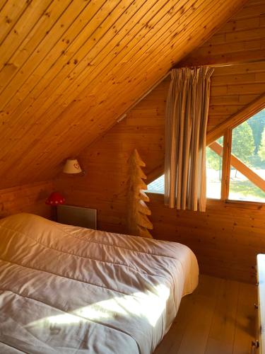a bedroom with a bed in a wooden cabin at Appartements duplex dans chalet - Pléiades -, skis aux pieds avec clefs à disposition via agence -nous louons l'un et-ou l'autre des deux appartements de notre chalet quasiment identiques in Risoul