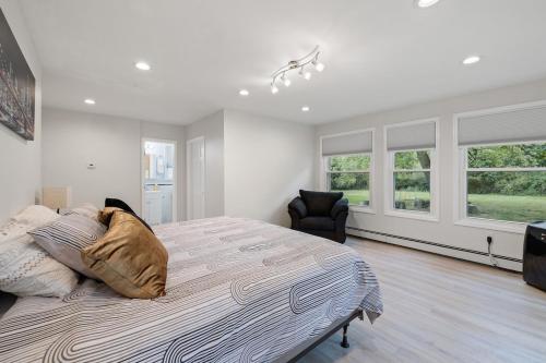 a bedroom with a large bed and two windows at Secluded Sanctuary in Nature in Monroe