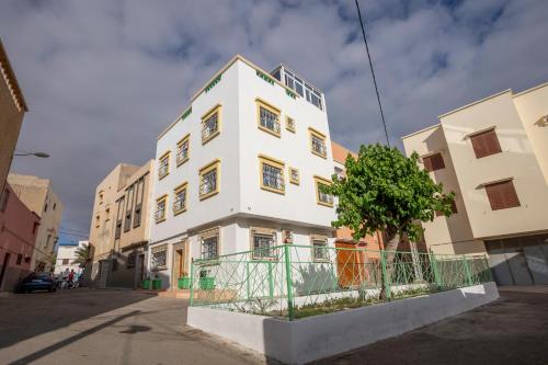a white building with a tree in front of it at Dar Diafa Anza in Agadir
