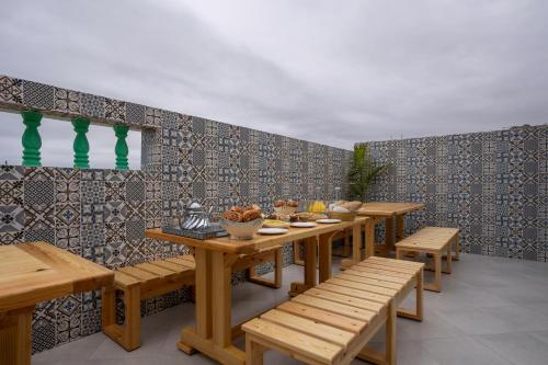 a row of tables and benches in a restaurant at Dar Diafa Anza in Agadir