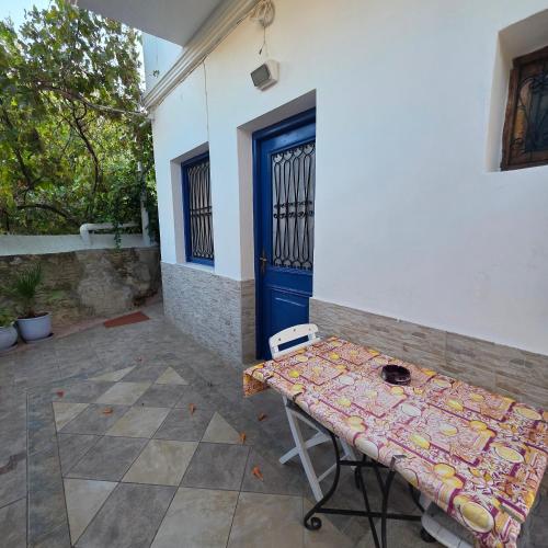 a table in front of a building with a blue door at "STELIOS & GALINI" in Symi