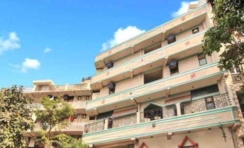 an apartment building with a blue sky in the background at Kerala Home Stay - Walking Distance From Nizamuddin Railway Station in New Delhi