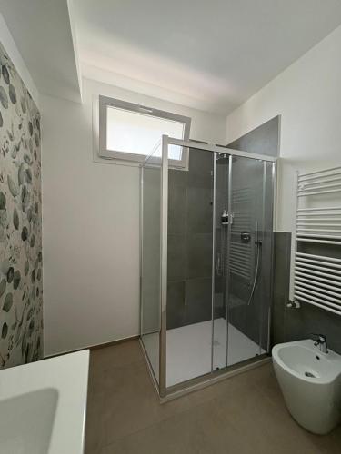 a bathroom with a shower and a toilet and a sink at Dimora Caprera - Appartamenti in Falconara Marittima