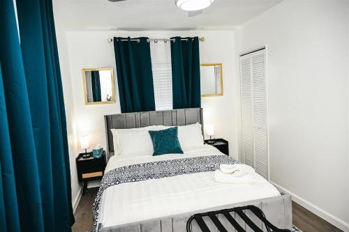 a bedroom with a large bed with blue curtains at Serenity Suite in Jacksonville