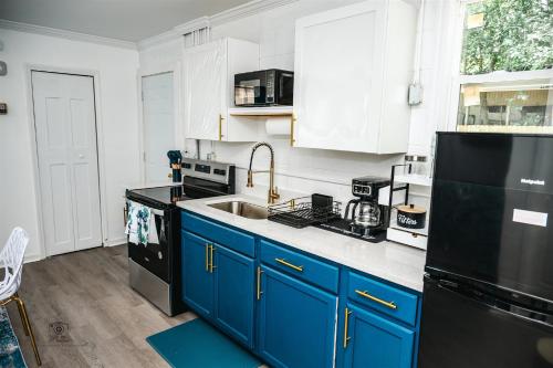 a kitchen with blue cabinets and a black refrigerator at Serenity Suite in Jacksonville
