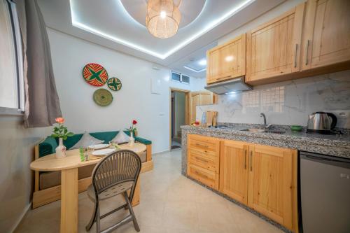 a kitchen with a table and a chair in it at Dar Diafa Anza in Agadir