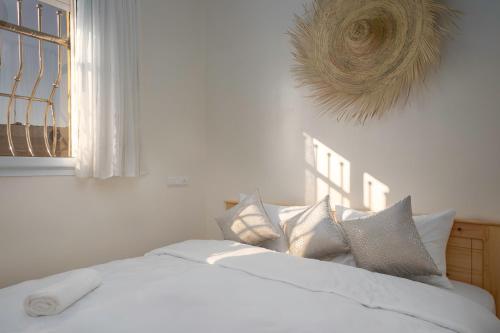 a bedroom with a white bed with pillows and a window at Dar Diafa Anza in Agadir