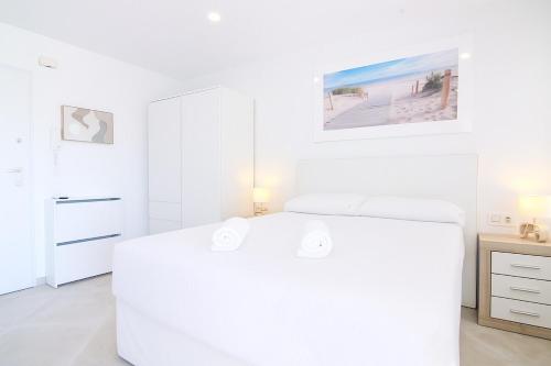 a white bedroom with a white bed and a desk at RiuRau Home - Studio 50 meters from the beach in Calpe
