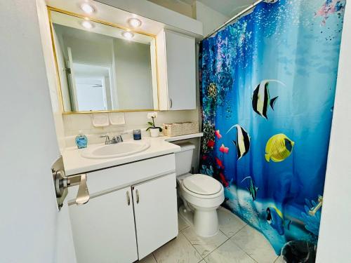 a bathroom with a sink and a shower curtain at Seaside Serenity in San Juan