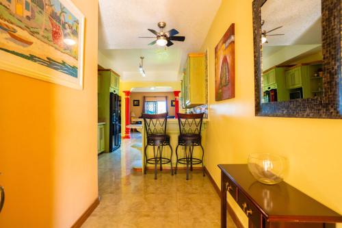 a kitchen with yellow walls and two bar stools at Dw apartments with garage and hot tub in Mandeville
