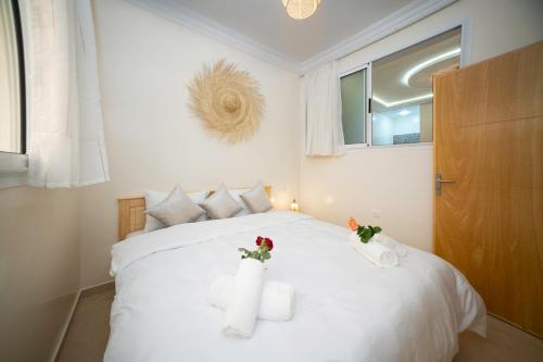 a bedroom with a white bed with two towels at Dar Diafa Anza in Agadir