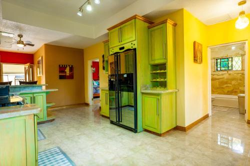 a kitchen with green cabinets and yellow walls at Dw apartments with garage and hot tub in Mandeville