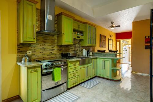 a green kitchen with yellow cabinets and a stove at Dw apartments with garage and hot tub in Mandeville