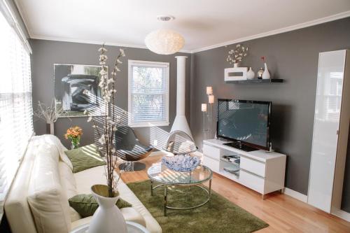 a living room with a white couch and a tv at Modern Apartment - Cameron Village in Raleigh