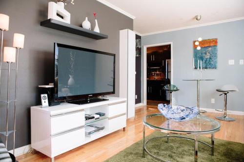 a living room with a tv and a glass table at Modern Apartment - Cameron Village in Raleigh