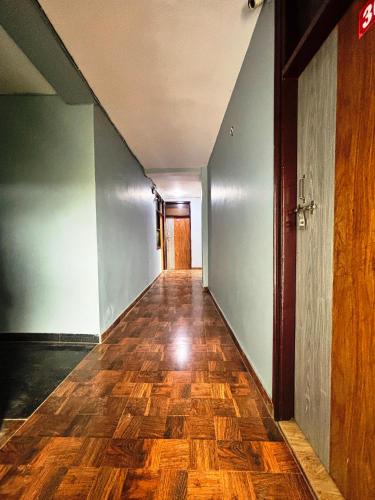 an empty hallway with a wooden floor and a door at Kerala Home Stay - Walking Distance From Nizamuddin Railway Station in New Delhi