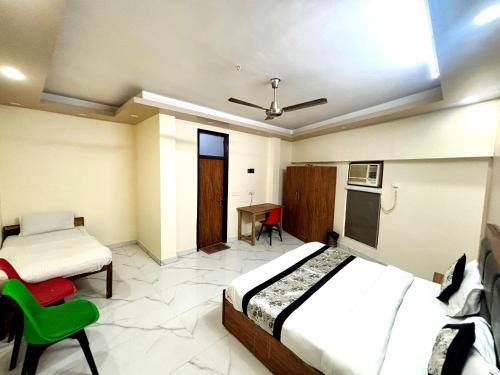 a bedroom with two beds and a desk in it at Kerala Home Stay - Walking Distance From Nizamuddin Railway Station in New Delhi