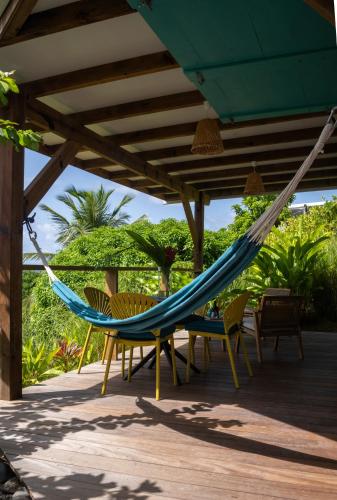 a hammock on a patio with chairs and trees at T1 Cosy la Kay émeraude-vue mer & surf-Tartane-Plage des surfeurs in La Trinité