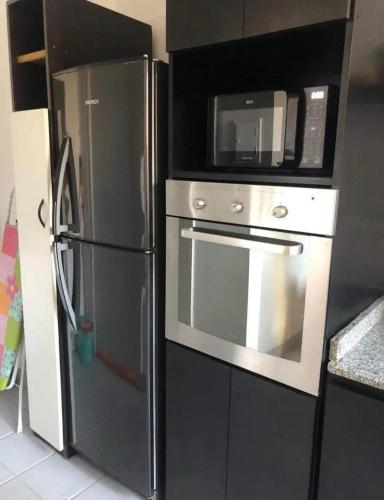 a kitchen with a black refrigerator and a microwave at Hogar de descanso in Mendoza