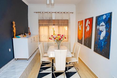 a dining room with a table with a vase of flowers on it at Casa tranquila in Kigali