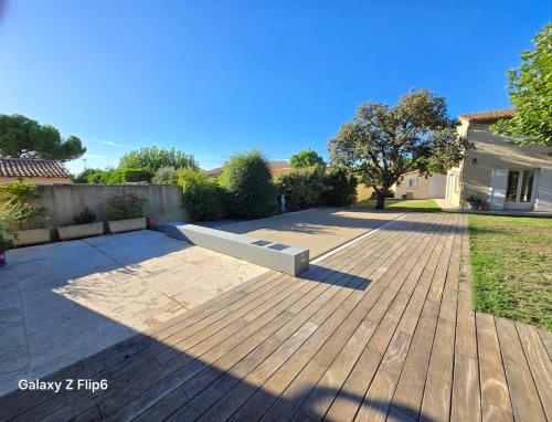 MeynesにあるNon-smoking house between Nîmes and Avignonの木製デッキのベンチ付きパティオ