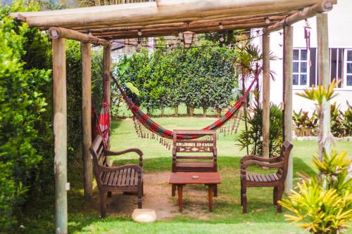 a hammock in a gazebo with two chairs at Pousada Portal de Paraty- COM GERADOR DE ENERGIA in Paraty