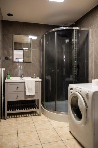 a bathroom with a washing machine and a shower at Ostoja Czersk Zamek Góra Kalwaria in Czersk