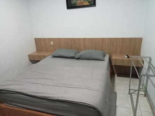 a bedroom with a bed with a wooden head board at Hotel Taman Rai in Tabanan