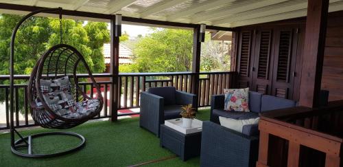 a porch with two chairs and a swing at Siberie Apartments Curaçao in Willibrordus