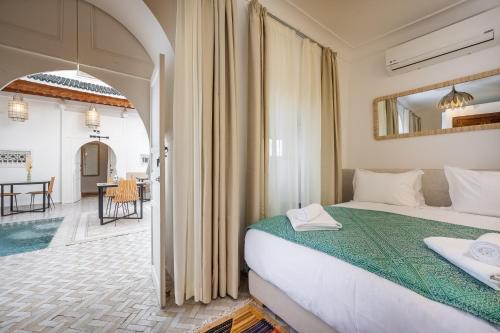 a bedroom with a bed and a living room at Riad LILIA in Marrakech