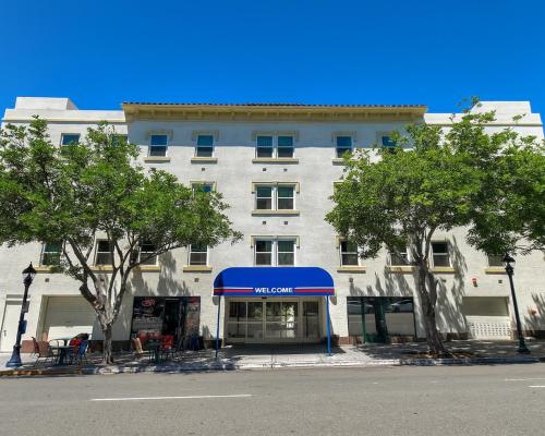 a large white building with a blue awning and trees at Motel 6-San Diego, CA - Downtown in San Diego