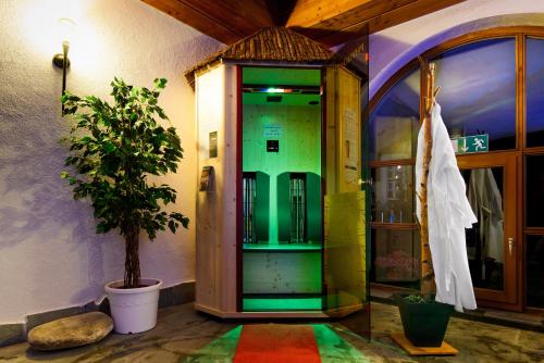 a green elevator in a room with a tree at Holzschuhs Schwarzwaldhotel in Baiersbronn