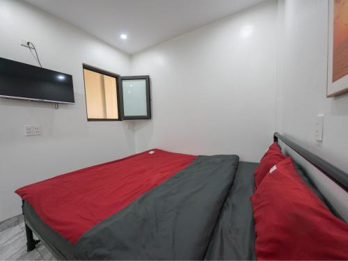 a room with a bed with a television on the wall at Strawberry House , Tour & Motorbikes Rentel in Ha Giang
