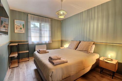 a bedroom with a bed with two towels on it at The Maisonnette in the pines in Ventabren