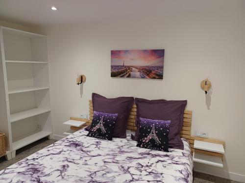 1 dormitorio con 1 cama con almohadas moradas en Plain-pied 80 m2 dans maison, parking privé gratuit, gare directe Paris, en Versalles